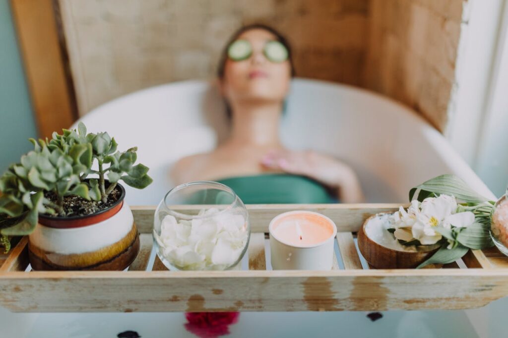 pexels-photo-6724383 Woman relaxing in a bathtub with a candle and plants, enjoying a serene spa experience.